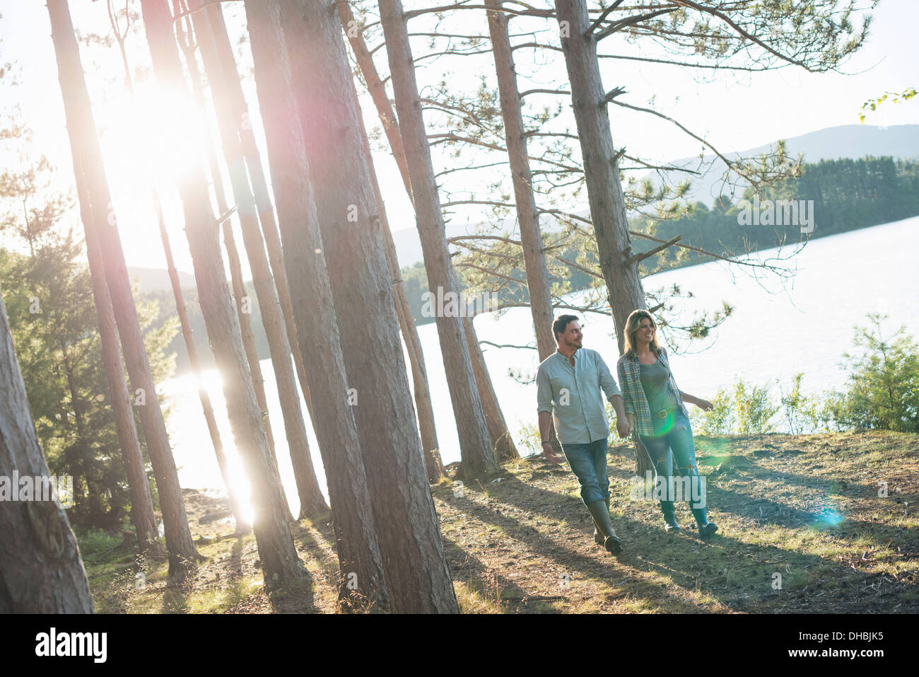 Un couple en train de marcher dans les bois sur les rives d'un lac. Banque D'Images