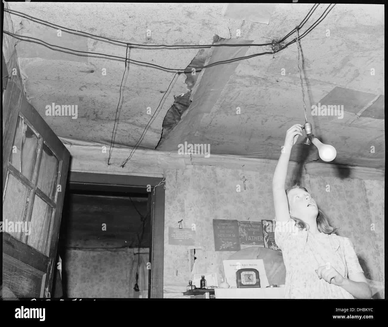 La fille de Gillie Treadway, une minière, est vue allumer la lumière électrique dans leur maison, illustrant l'adoption de l'électricité dans les communautés minières au début du XXe siècle. Banque D'Images