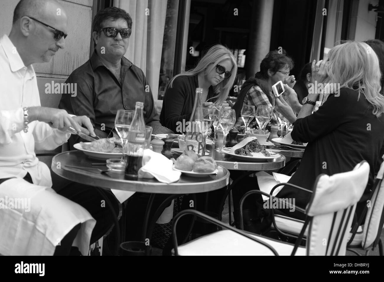 Les gens en train de déjeuner sur une terrasse dans les rues de Paris. Banque D'Images