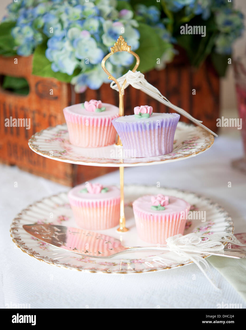 Un système à deux niveaux cake stand avec cup cakes et silver cake slice Banque D'Images