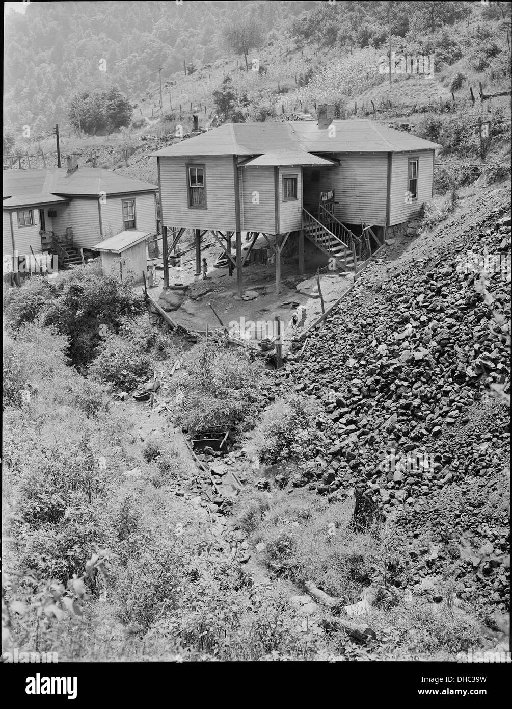 Cette image montre des maisons et un fossé près de la Mullens Smokeless Coal Company et de la mine Mullens à Harmco, dans le comté du Wyoming, en Virginie-occidentale. Il offre un aperçu du paysage résidentiel et minier de la région. Banque D'Images