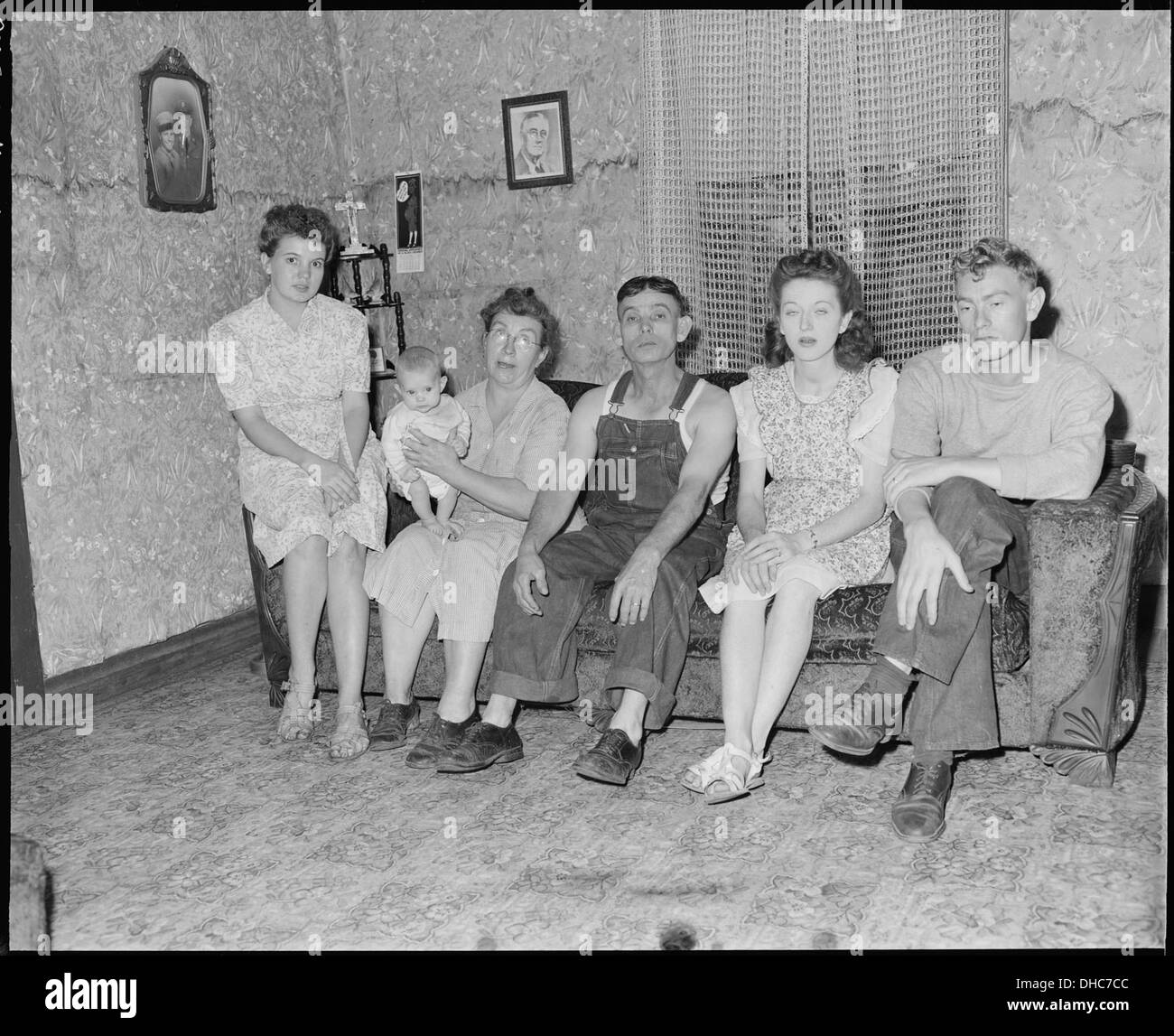M.R. et M.R. Theo Sizemore sont montrés avec leur fils, leurs deux belles-filles et leur petit-enfant dans le salon de leur modeste maison de quatre pièces, reflétant la vie familiale au milieu du XXe siècle en Amérique. Banque D'Images