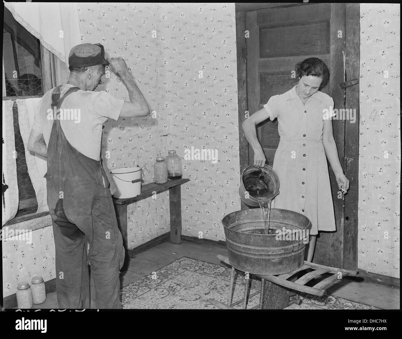 Mme Sergent Blaine se déverse l'eau du bain pour son mari, cette société n'a pas de baignoire chambre, il n'y en a aucune... 541290 Banque D'Images