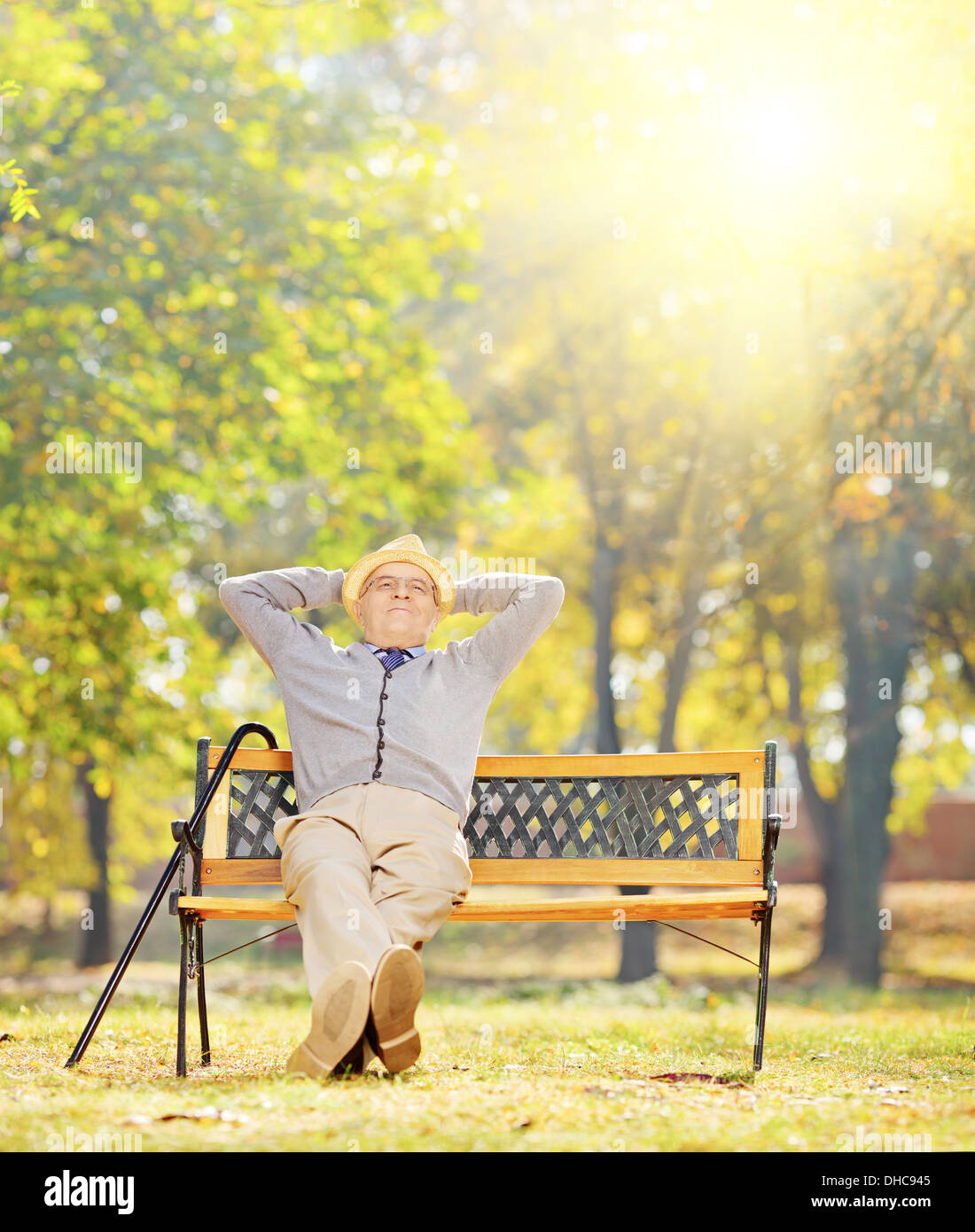La haute atmosphère assis sur un banc en bois dans un parc sur une journée ensoleillée Banque D'Images
