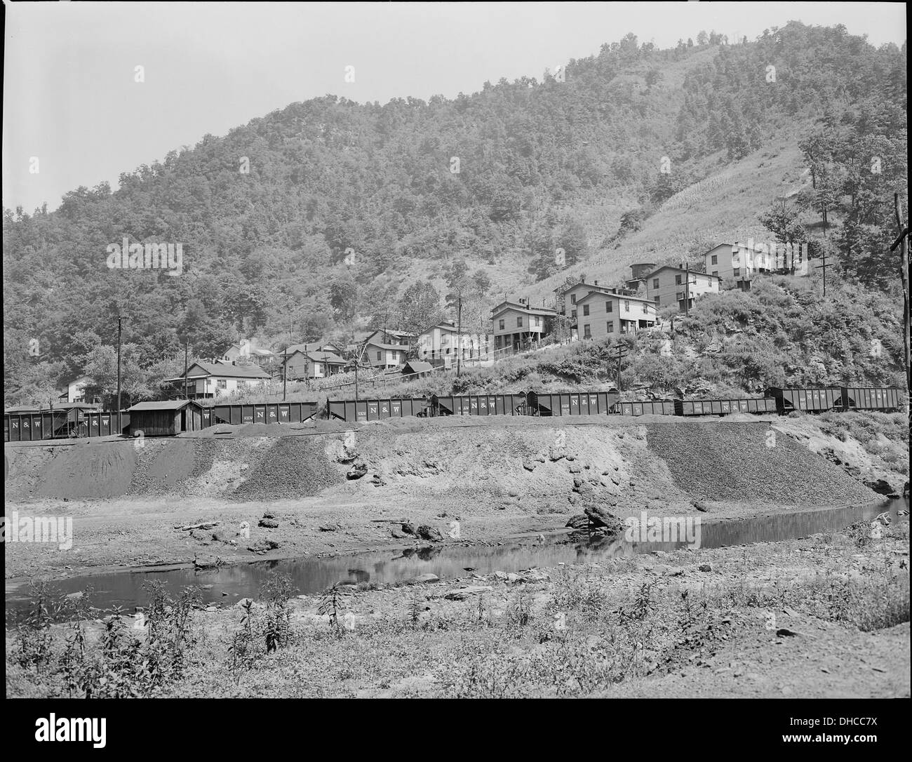 Cette photographie représente une décharge d'ardoise et les gares de triage reliées à la Southern Coal Corporation à Bradshaw, dans le comté de McDowell, en Virginie-occidentale. Le projet de logement de la compagnie a servi les travailleurs de la mine voisine, reflétant l'histoire industrielle de la région. Banque D'Images
