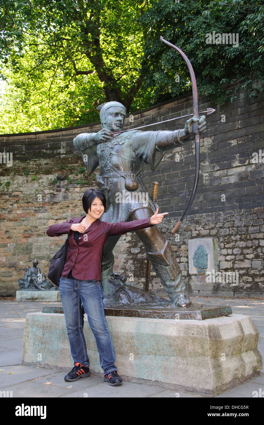 Touriste japonais qui pose à côté de la statue de Robin des Bois, Nottingham, England, UK Banque D'Images