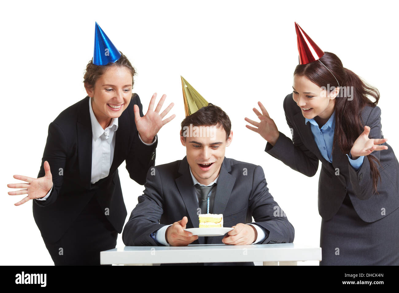 Portrait of young businessman in anniversaire cap à la recherche au morceau de gâteau avec deux femelles joyeuse près de par Banque D'Images