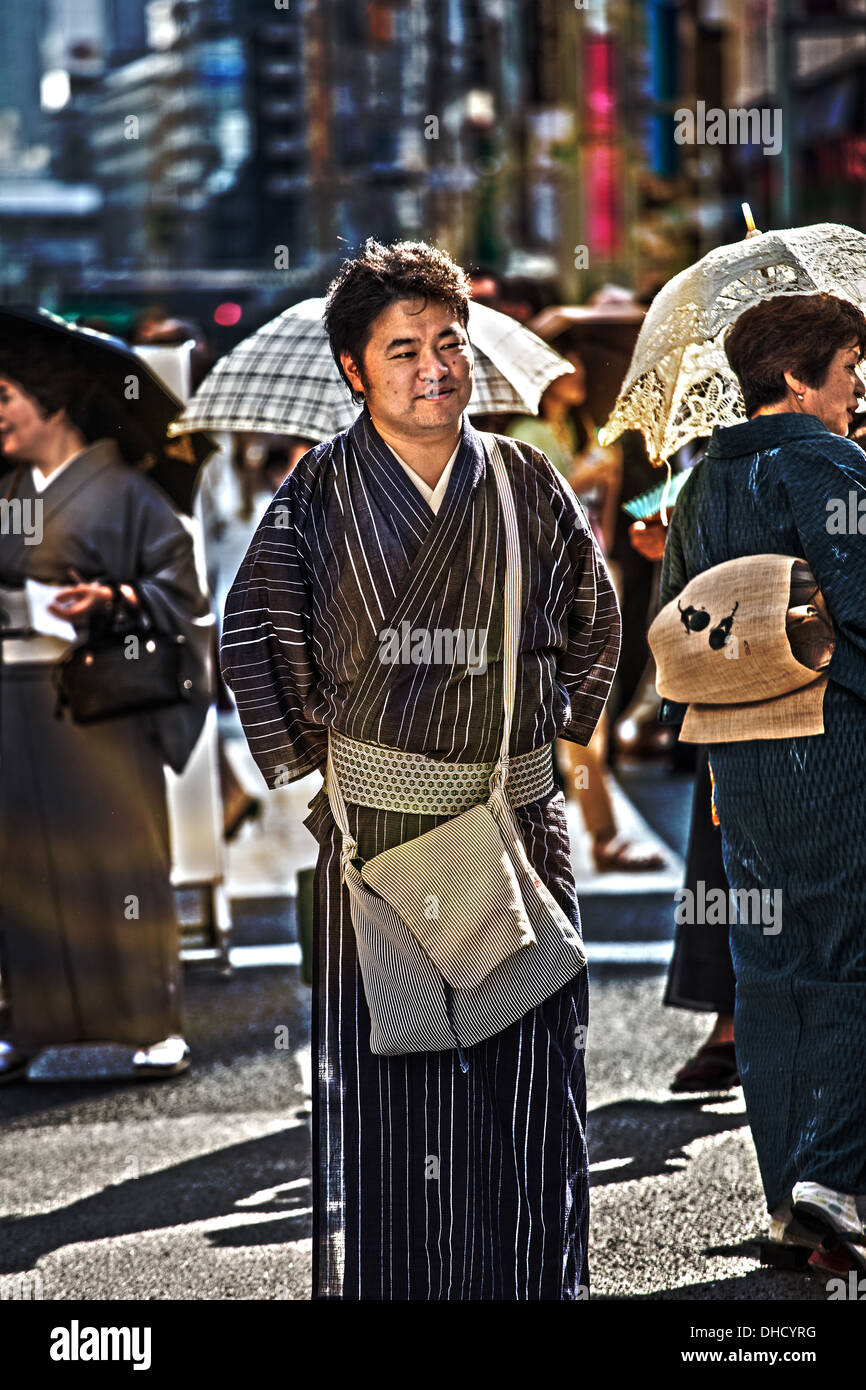 Un homme japonais de 20 à 30 ans portant des vêtements traditionnels dans une rue de Tokyo, Japon. L'image est en format portrait Banque D'Images