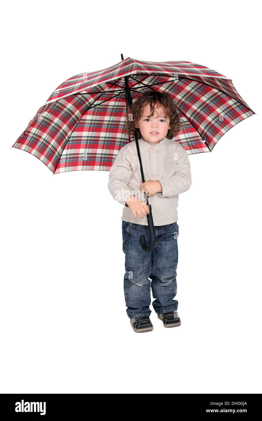 Jeune garçon tenant un parapluie ouvert Banque D'Images