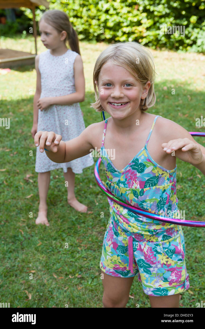 Happy girl with hula hoop dans jardin Banque D'Images