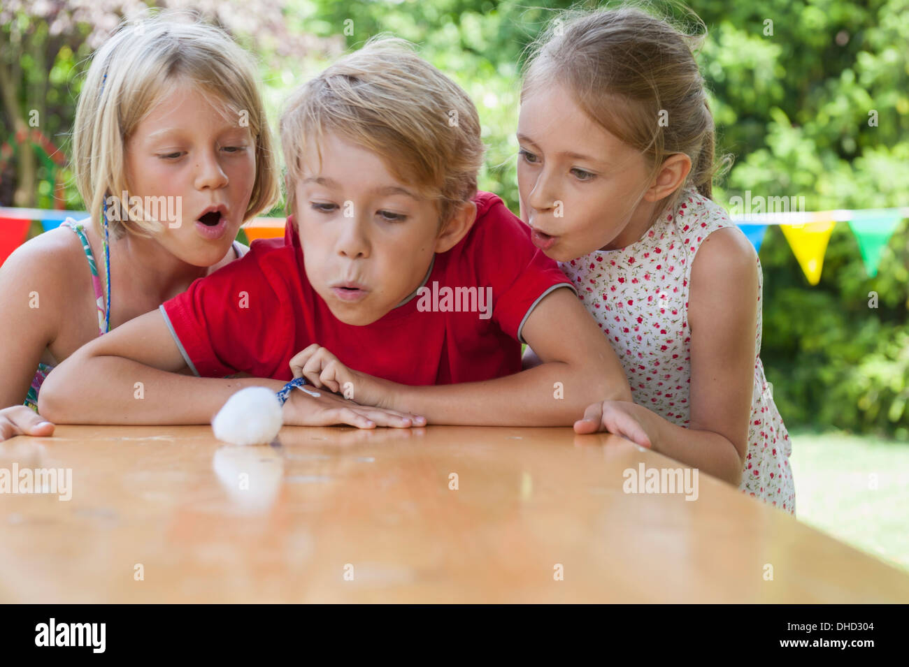 Soufflage enfants boule de coton sur la table de jardin Banque D'Images
