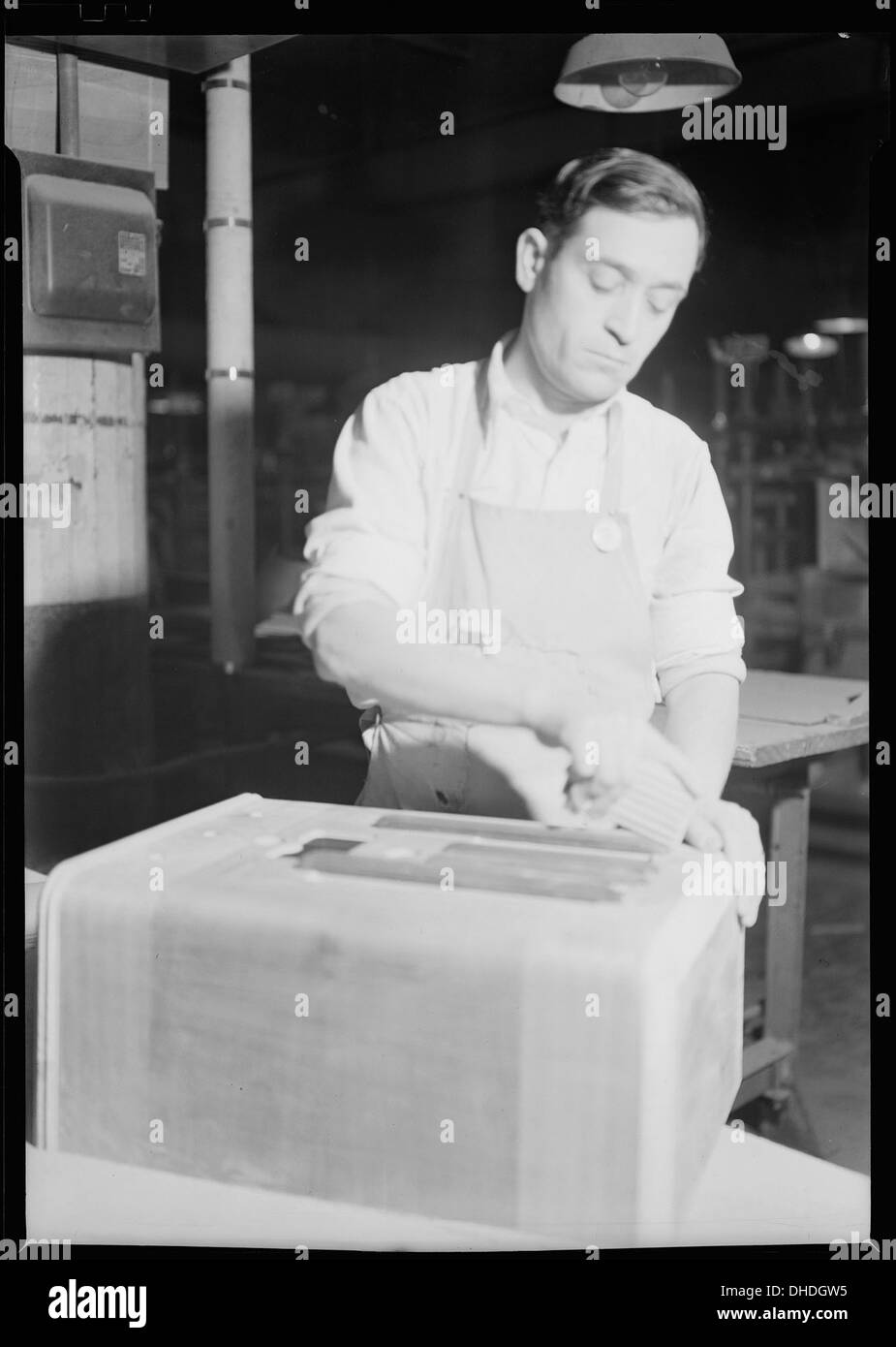 Une photographie en gros plan d’une ponceuse utilisée dans l’usine de fabrication d’armoires de RCA Victor à Camden, New Jersey, mettant l’accent sur l’artisanat du travail du bois dans le processus de fabrication. Banque D'Images