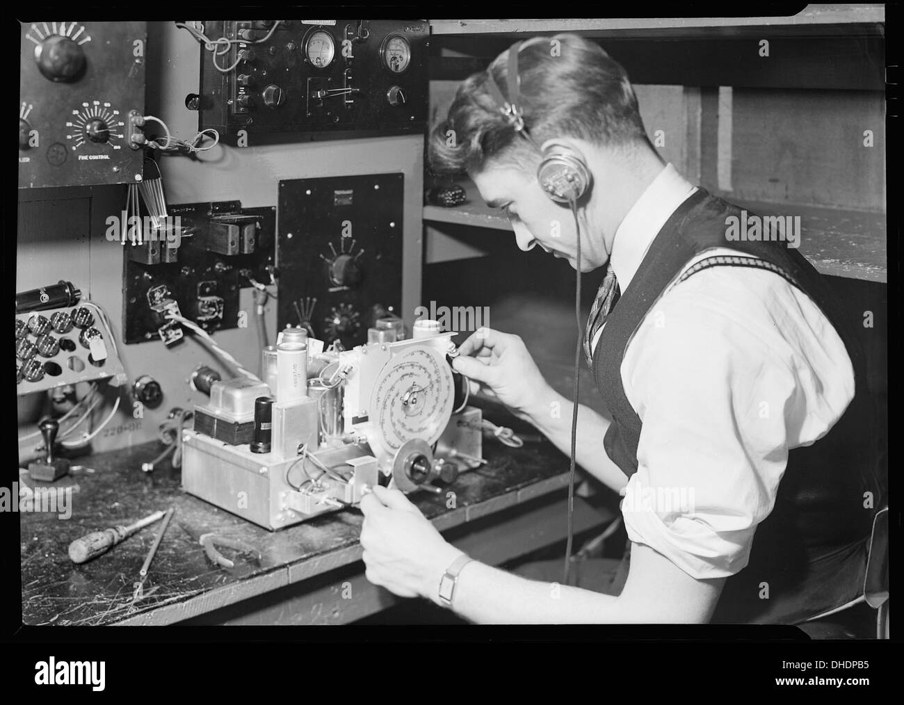 Un inspecteur final de RCA Victor à Camden, New Jersey, teste l'alignement des fréquences radio et effectue des vérifications finales sur les radios, garantissant ainsi la qualité des produits dans l'industrie électronique du XXe siècle. Banque D'Images