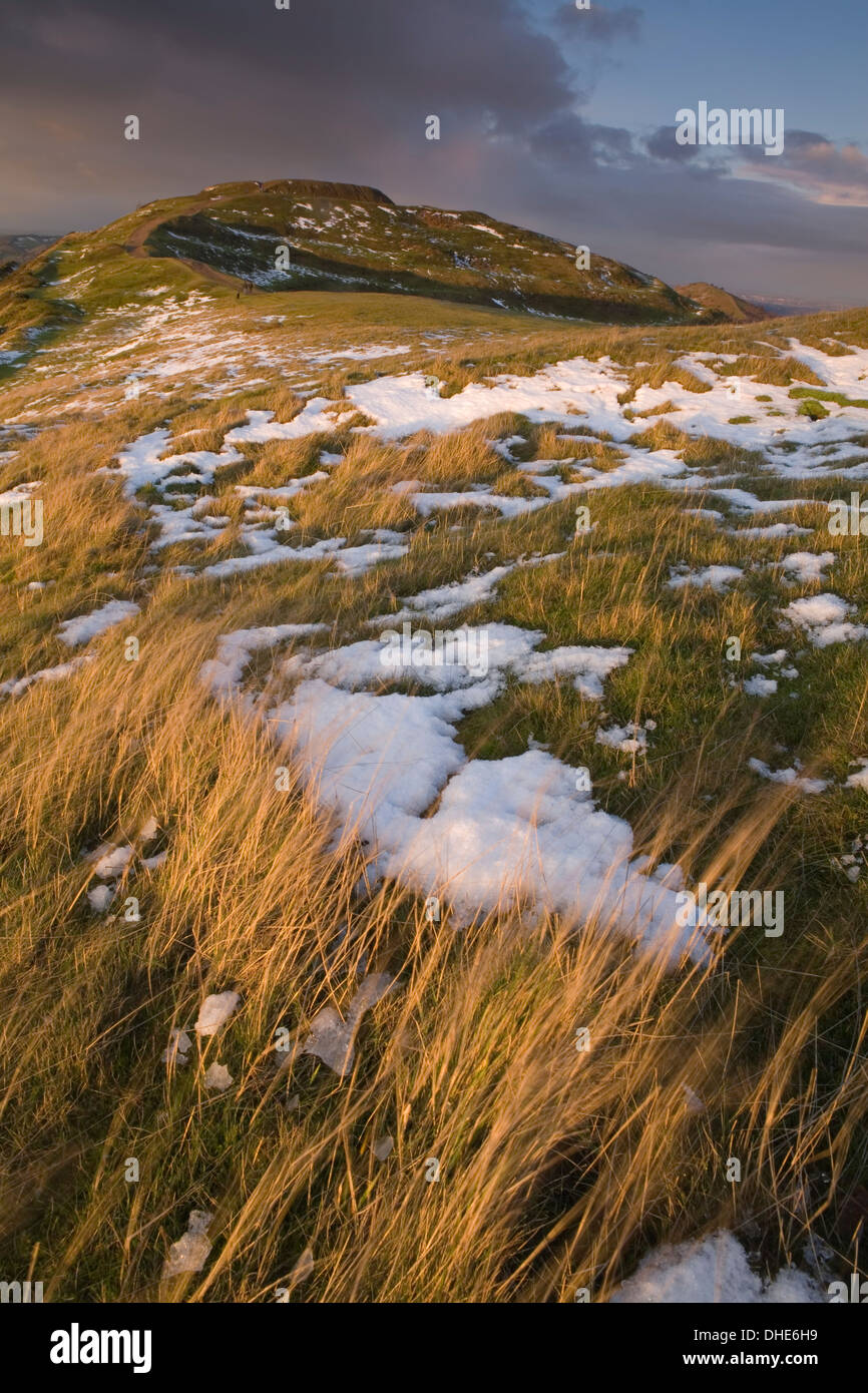 Les dernières plaques de neige sur l'Herefordshire Beacon prendre le coucher du soleil la lumière. Banque D'Images