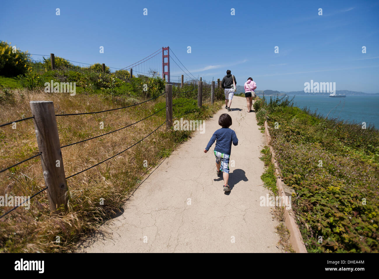 Les parents de l'enfant qui court après le sentier - San Francisco, California USA Banque D'Images