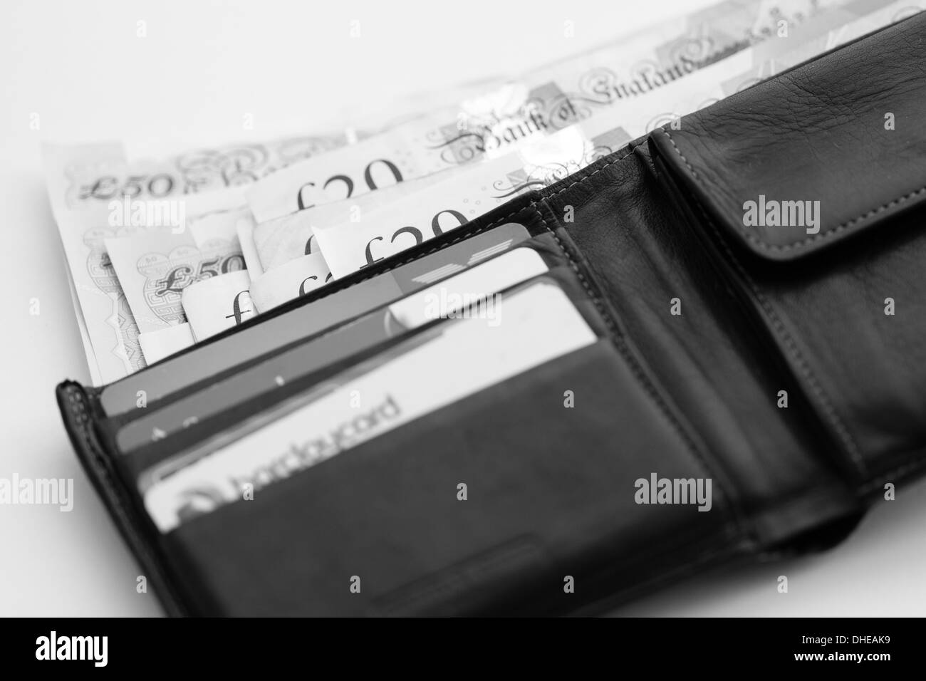 Portefeuille ouvert montrant les billets en livre sterling 20 £ et 50 £ de dominations, avec des poches séparées contient des cartes de crédit y compris Barclaycard. Banque D'Images