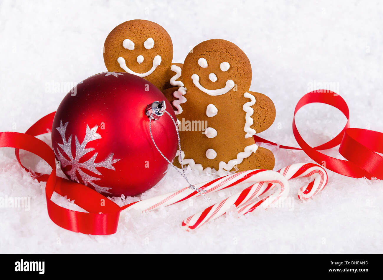 Gingerbread Man cookies et des cannes de bonbon avec boule de noël ornement rouge sur fond de neige Banque D'Images