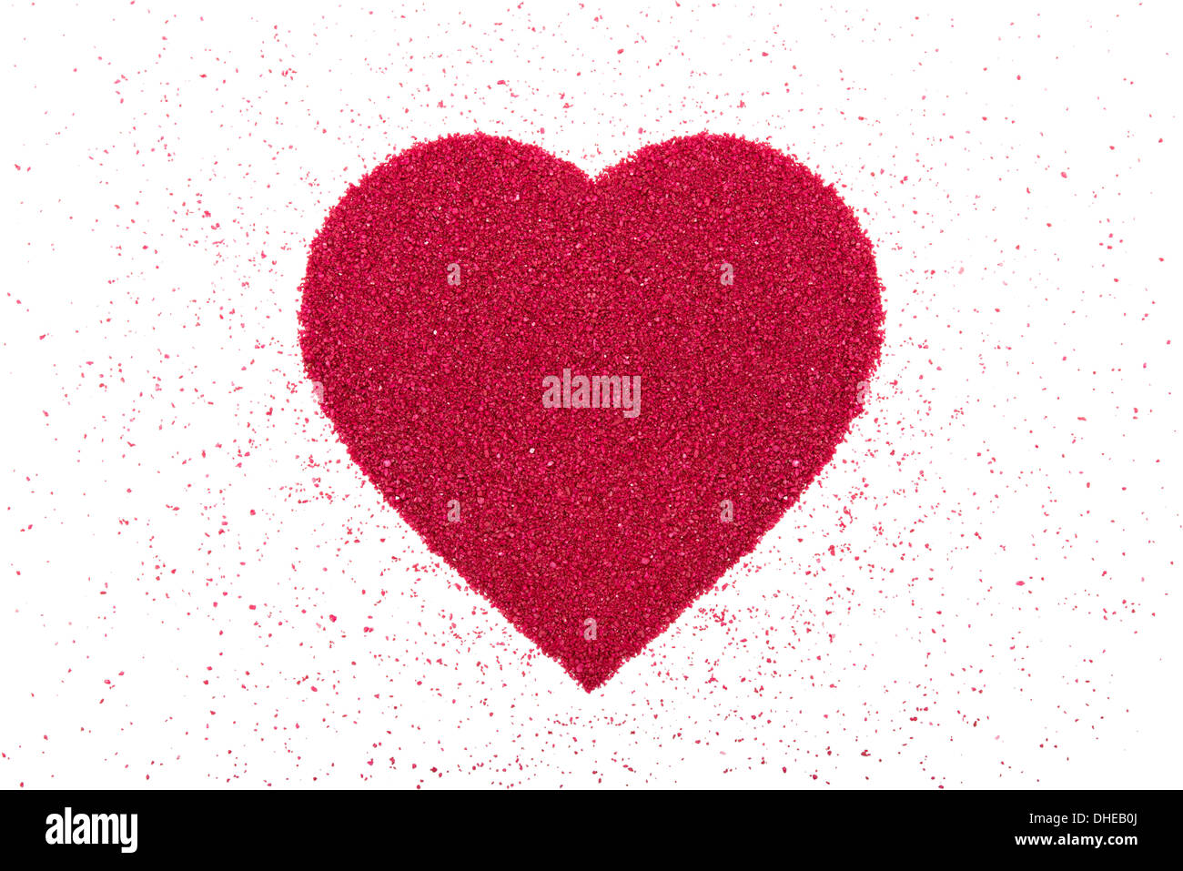 Cœur fait de sable décoratif rouge est sur un fond blanc. Banque D'Images