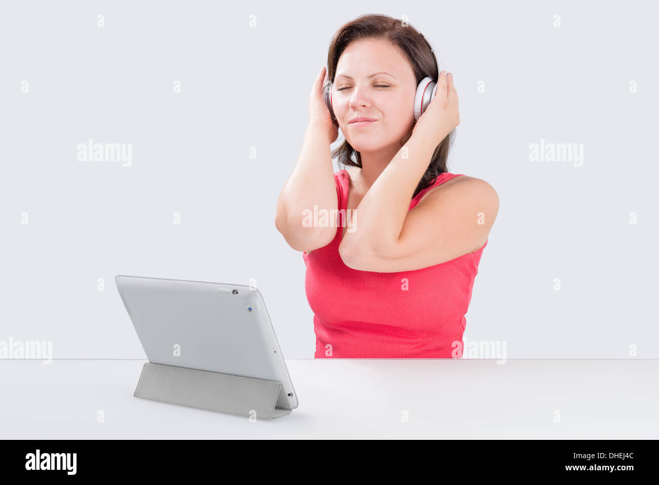 Jeune femme est à l'écoute de la musique via un casque bluetooth par digital tablet et rêver Banque D'Images