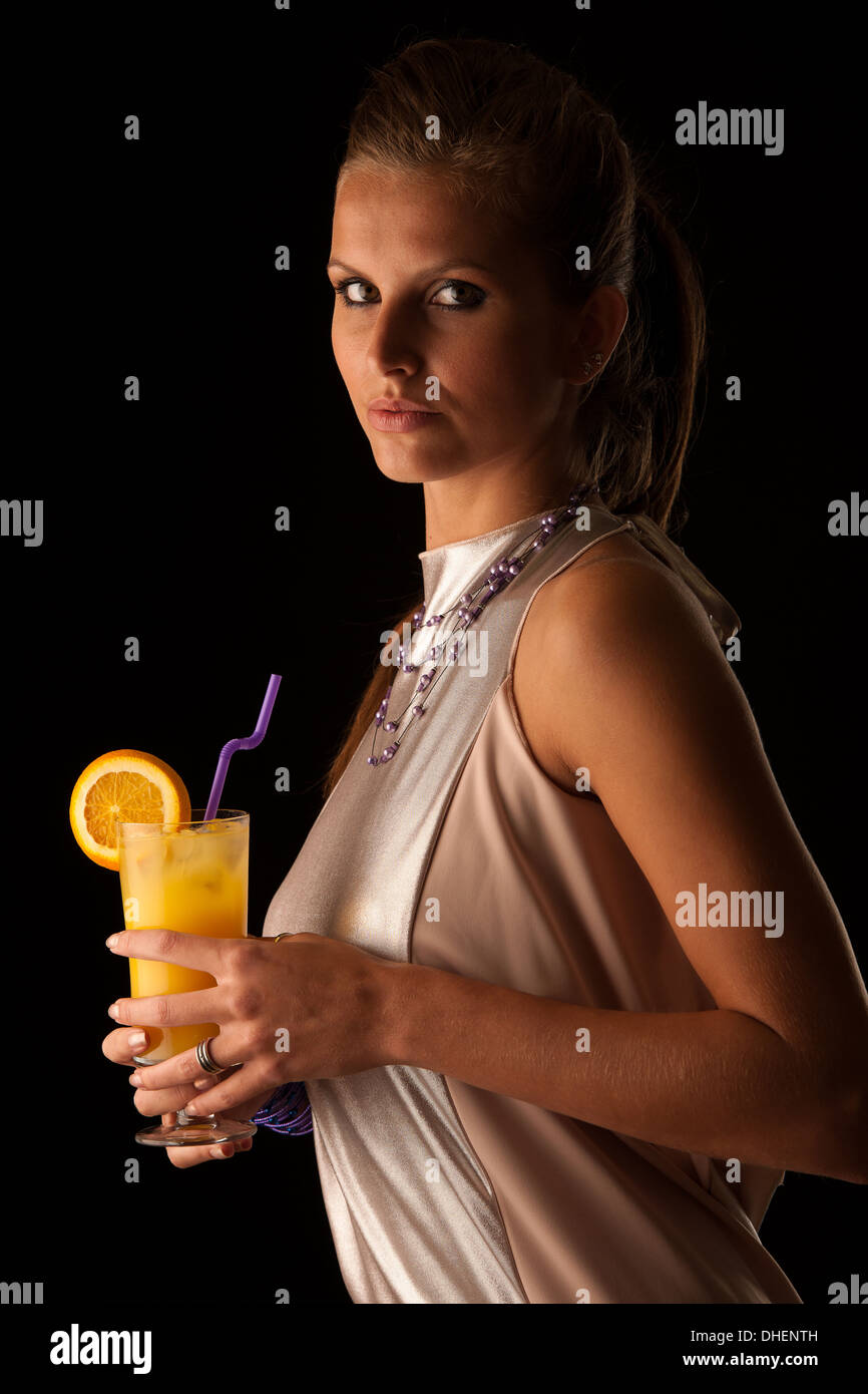 Belle jeune femme avec cocktail isolated over fond noir Banque D'Images