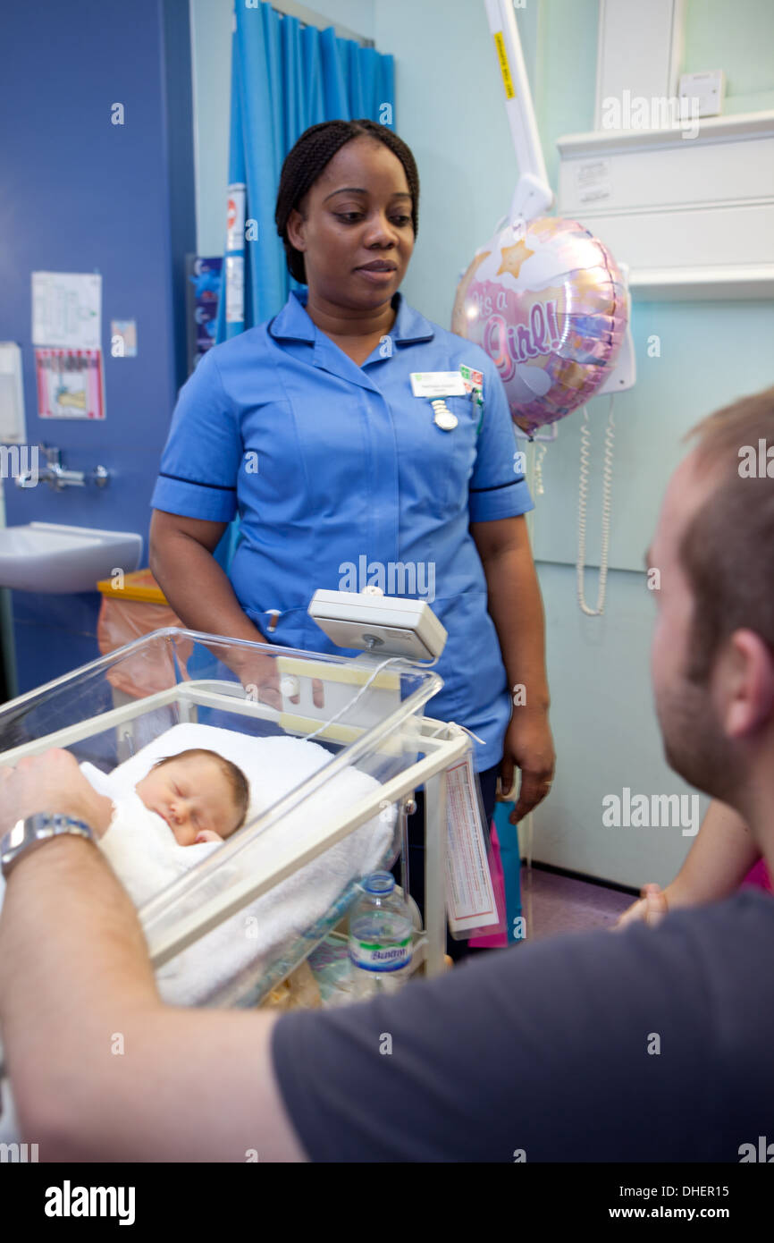 Une sage-femme, des entretiens avec les parents d'un bébé nouveau-né UK Banque D'Images