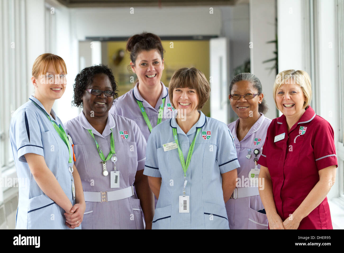 Un groupe de 5 infirmières sourire vers la caméra dans un couloir de l'hôpital UK Banque D'Images