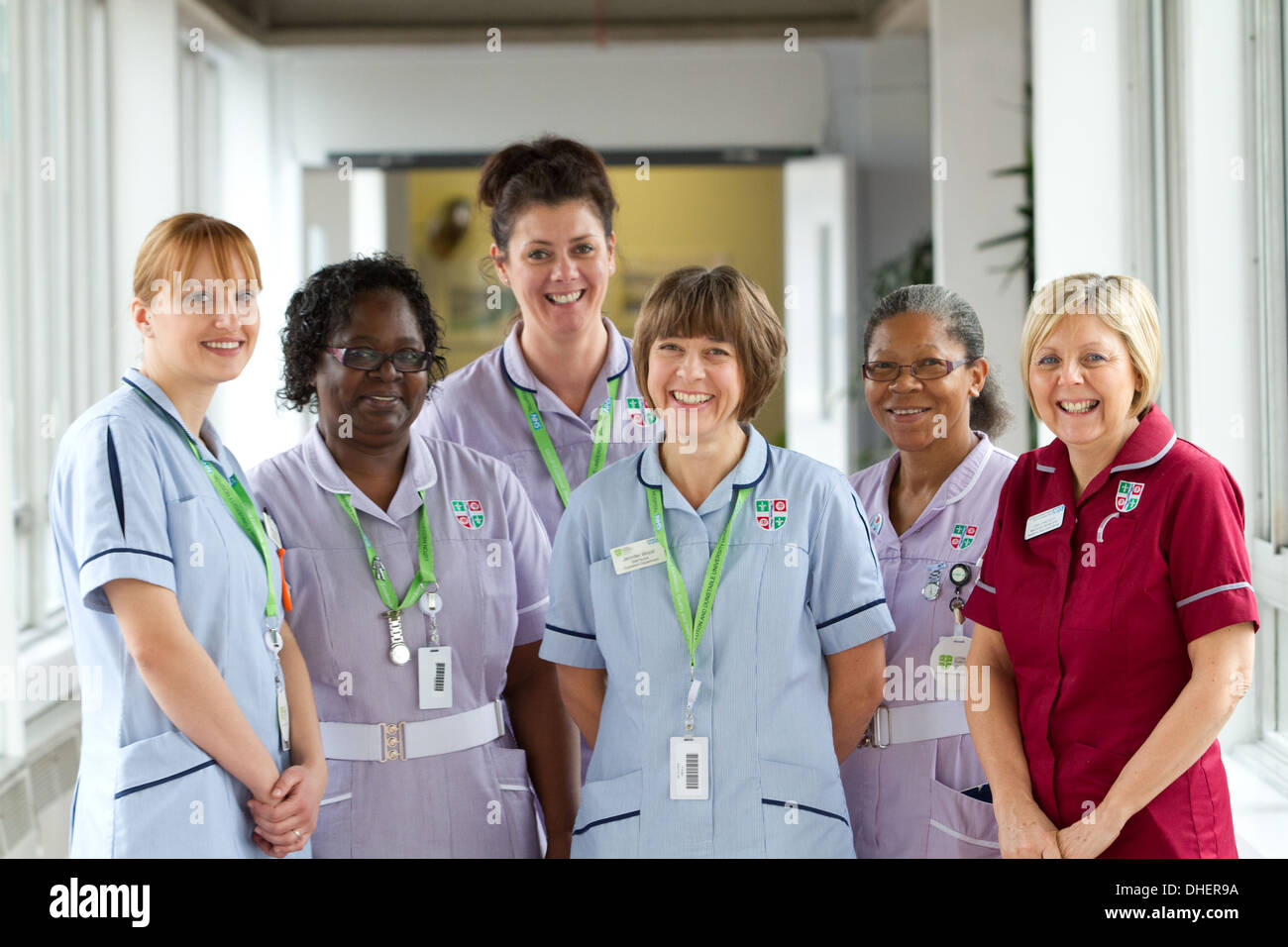 Un groupe de 5 infirmières sourire vers la caméra dans un couloir de l'hôpital UK Banque D'Images
