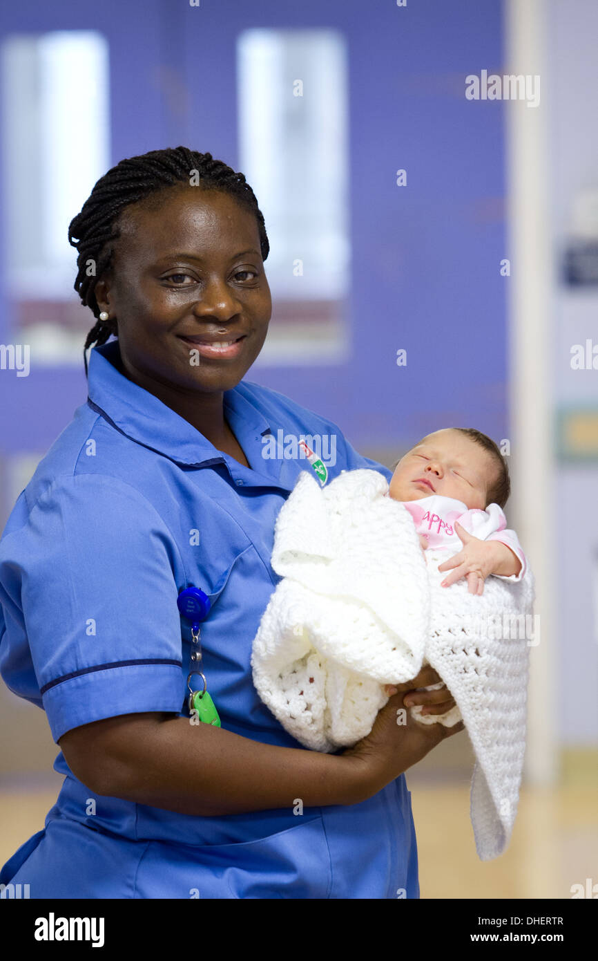 Une sage-femme est titulaire d'un bébé nouveau-né dans un couloir de l'hôpital UK Banque D'Images