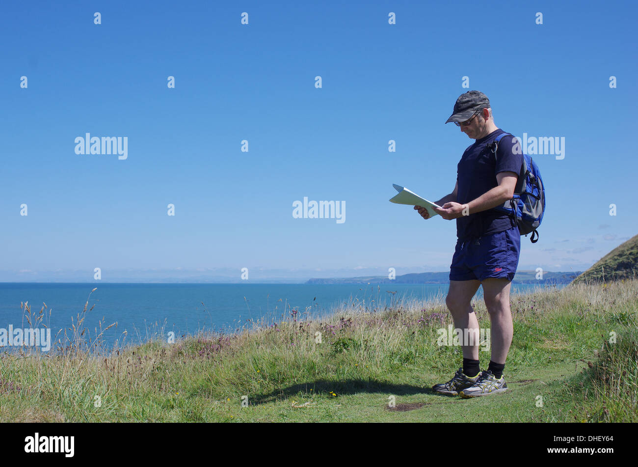 La fin de l'homme de 45 ans à la recherche sur la carte. Beau paysage et la  côte de Mwnt, La Baie de Cardigan, l'ouest du pays de Galles. Copie espace,  ciel