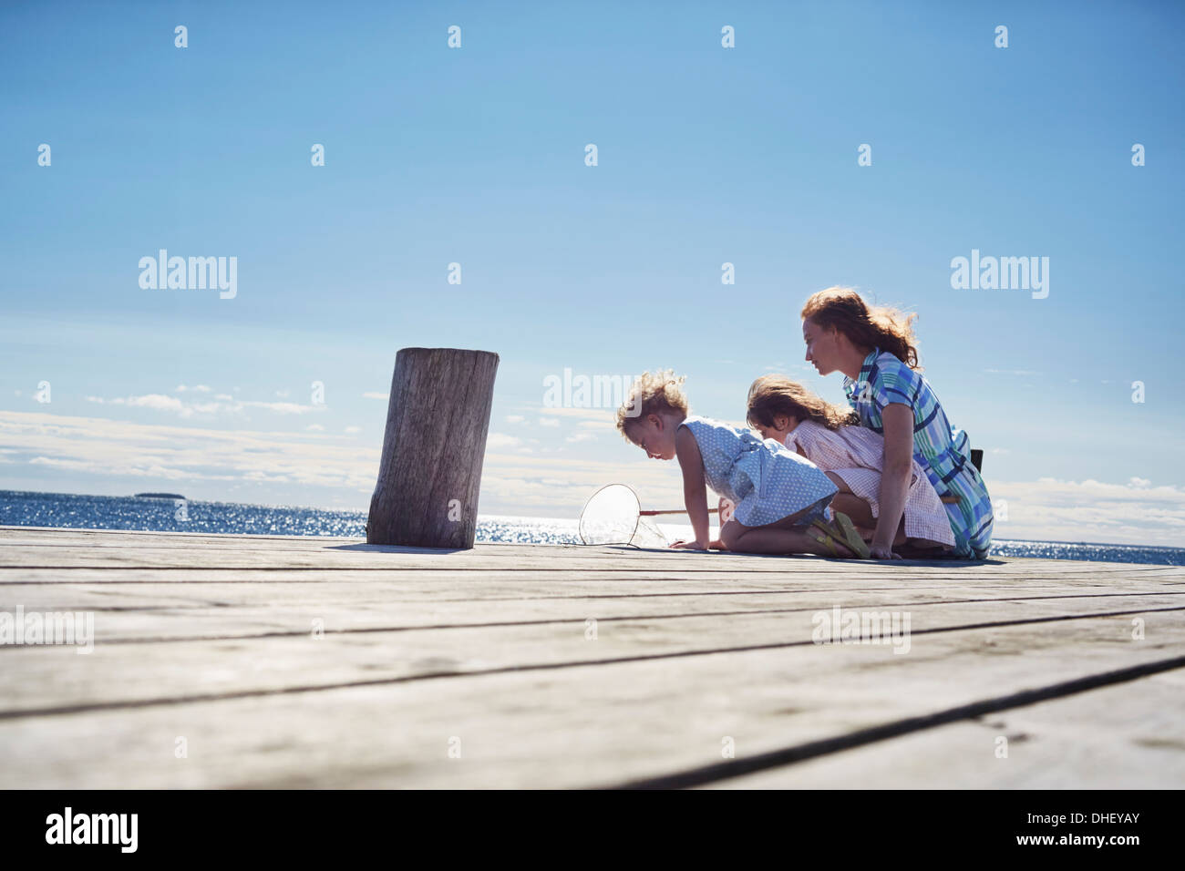 La mère et les filles jouant sur jetty, Utvalnas, Gavle, Suède Banque D'Images