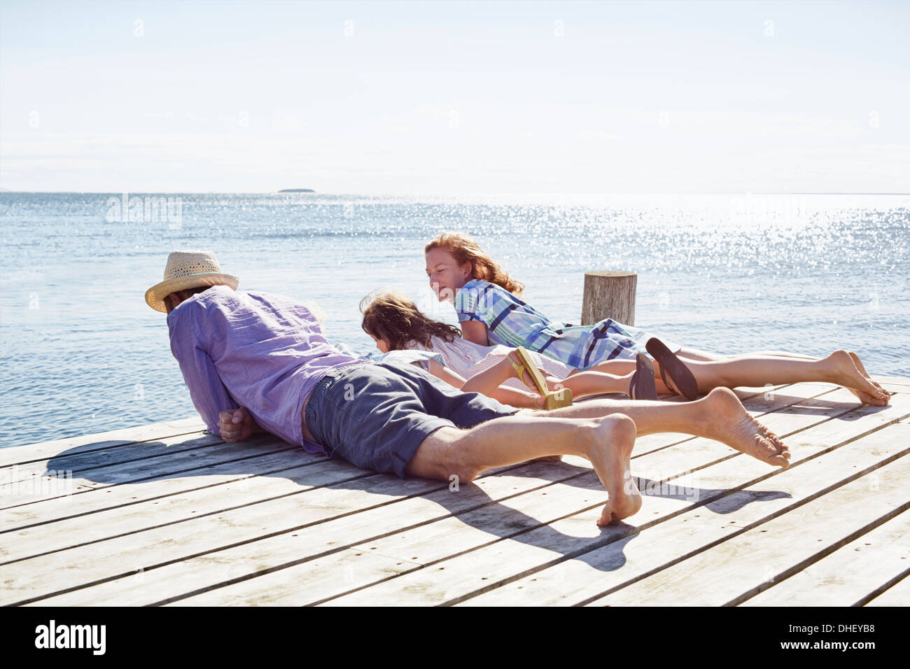 Family lying on pier, Utvalnas, Gavle, Suède Banque D'Images