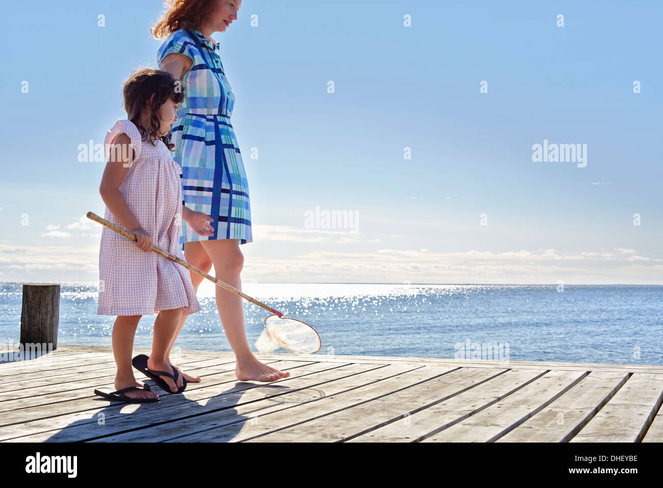 Mère et fille sur la jetée avec filet de pêche, Utvalnas, Gavle, Suède Banque D'Images