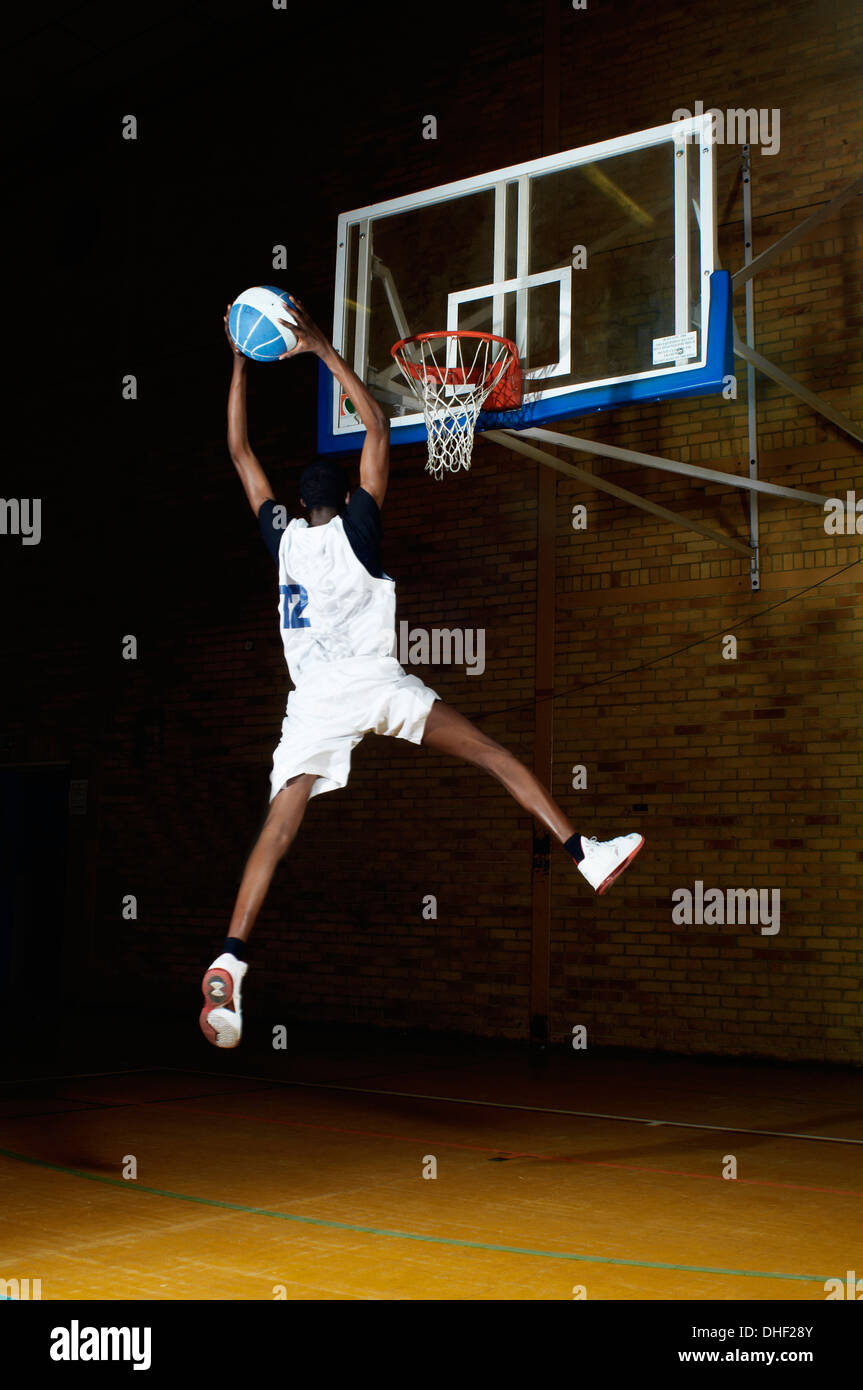 Basket-ball player jumping with ball Banque D'Images
