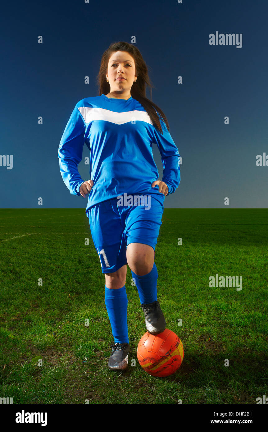 Portrait de femme avec le pied sur le ballon de football Banque D'Images