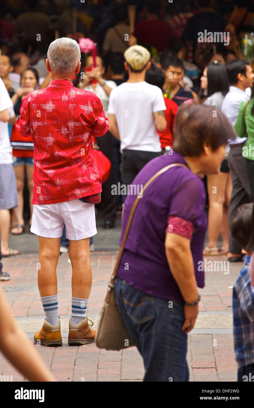 Personnes âgées à l'extérieur de l'homme Oriental adore Kwan Inn Tong Temple Bouddhiste, Singapour. Banque D'Images