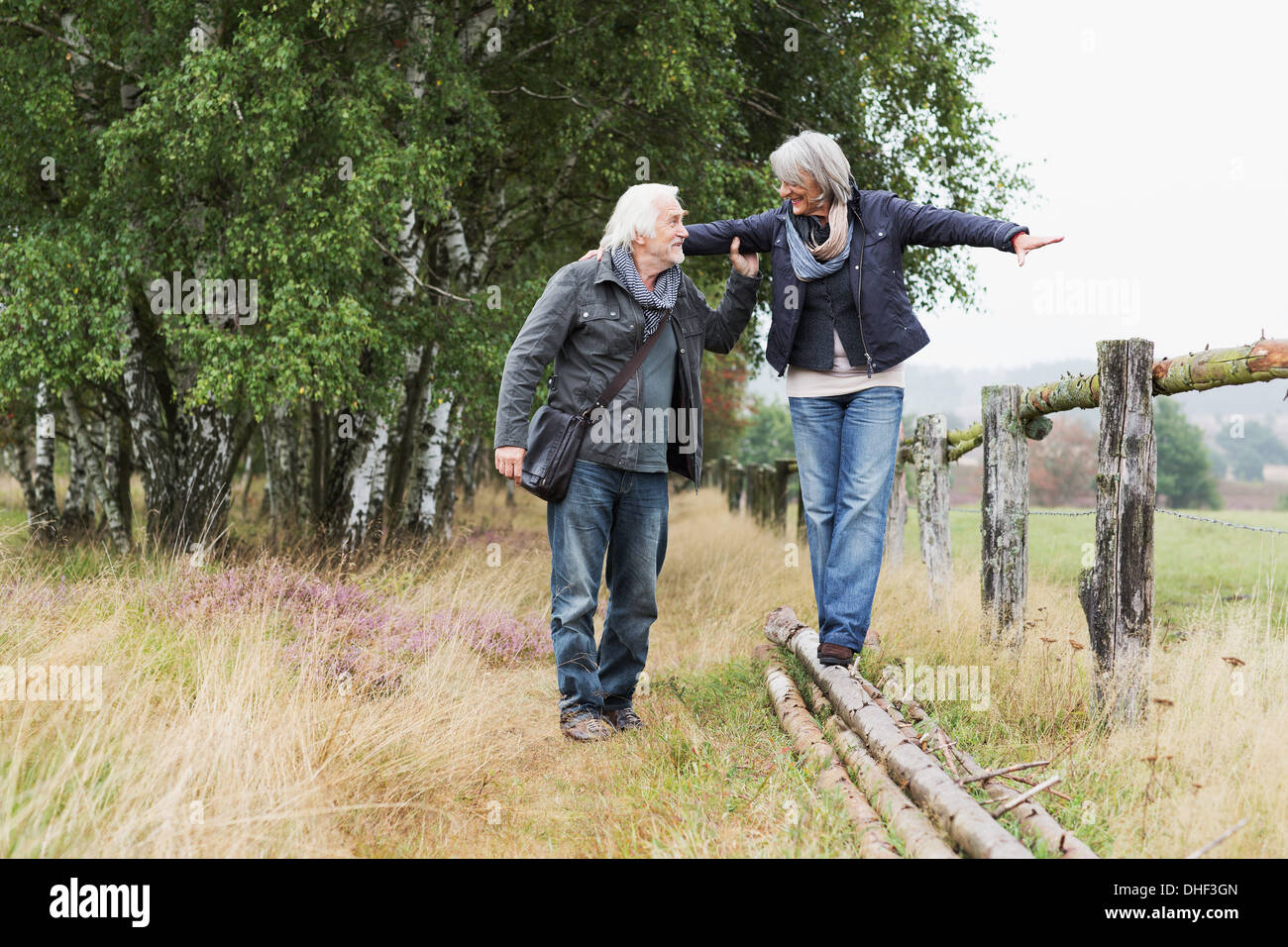 Couple, woman balancing on logs Banque D'Images