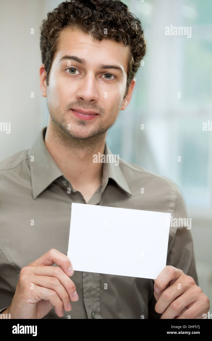 Jeune homme tenant une carte blanche Banque D'Images