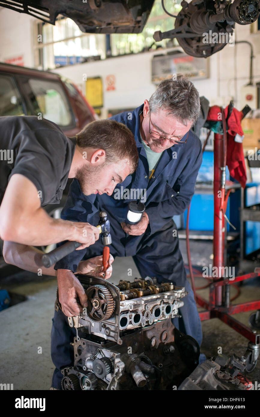 Mécaniciens travaillant sur le moteur de la voiture en garange Banque D'Images