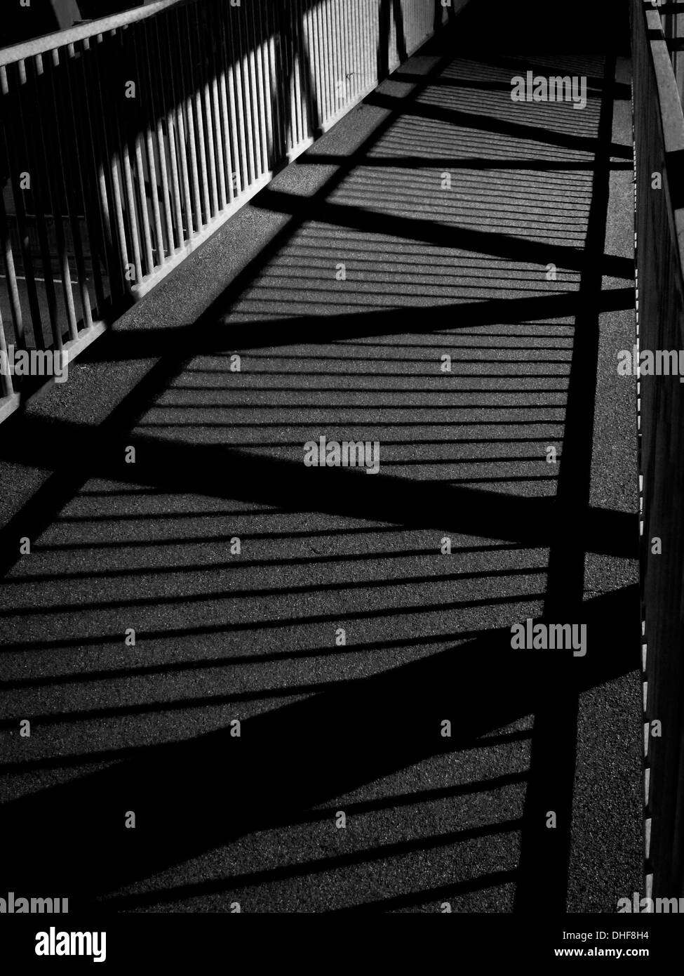 Ombres projetées par des lumières de rue la nuit sur passerelle sur la route A12, Wanstead, London Banque D'Images