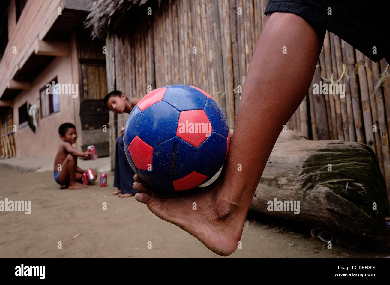 Jeune garçon jouant au football dans Sugtupu Carti island village administré par Guna autochtones connue sous le nom de la "Comarca Kuna" (région) de la Guna Yala située dans l'archipel de San Blas Blas dans le nord-est du Panama vers la mer des Caraïbes. Banque D'Images