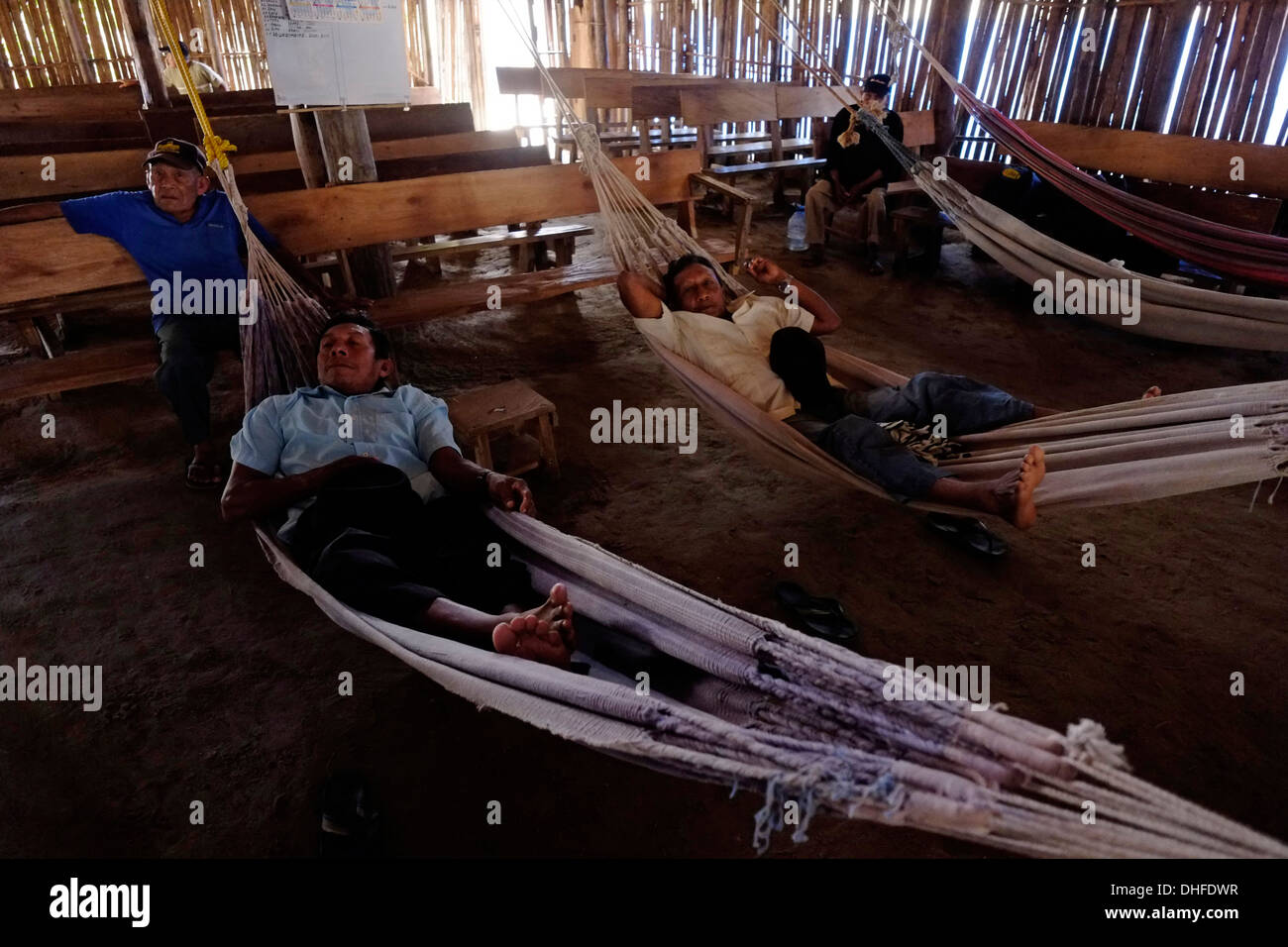 Les dirigeants autochtones Kuna Yala au repos dans des hamacs dans le Onmaked Nega, Palais des Congrès, la maison ou la Casa de Castro, une structure qui sert à la fois politique et spirituel en Sugtupu Carti island village administré par Guna autochtones connue sous le nom de la "Comarca Kuna" (région) de la Guna Yala située dans l'archipel de San Blas Blas dans le nord-est du Panama vers la mer des Caraïbes. Banque D'Images