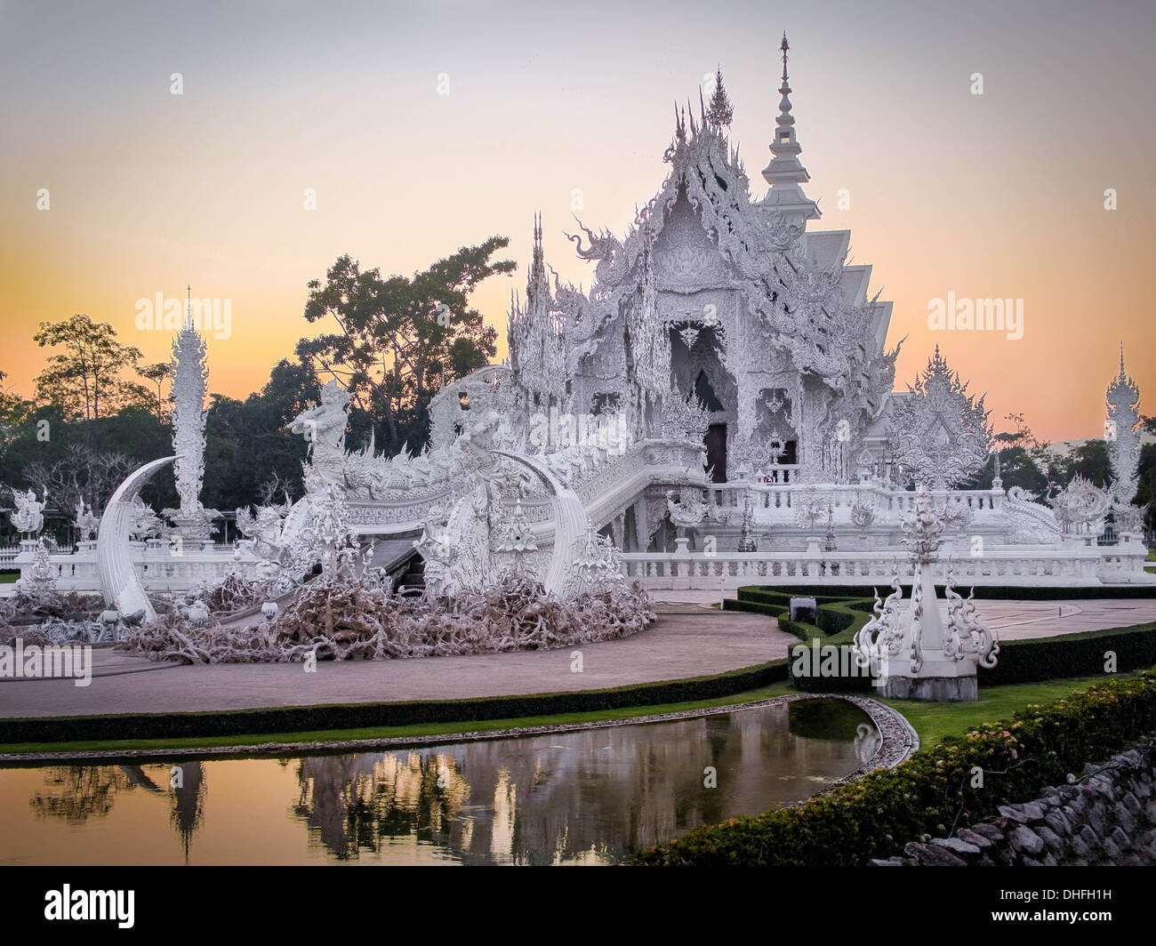 Le magnifique Wat Rong Khun, communément appelé le Temple blanc, au coucher du soleil à Chiang Rai, dans le Nord de la Thaïlande. Banque D'Images