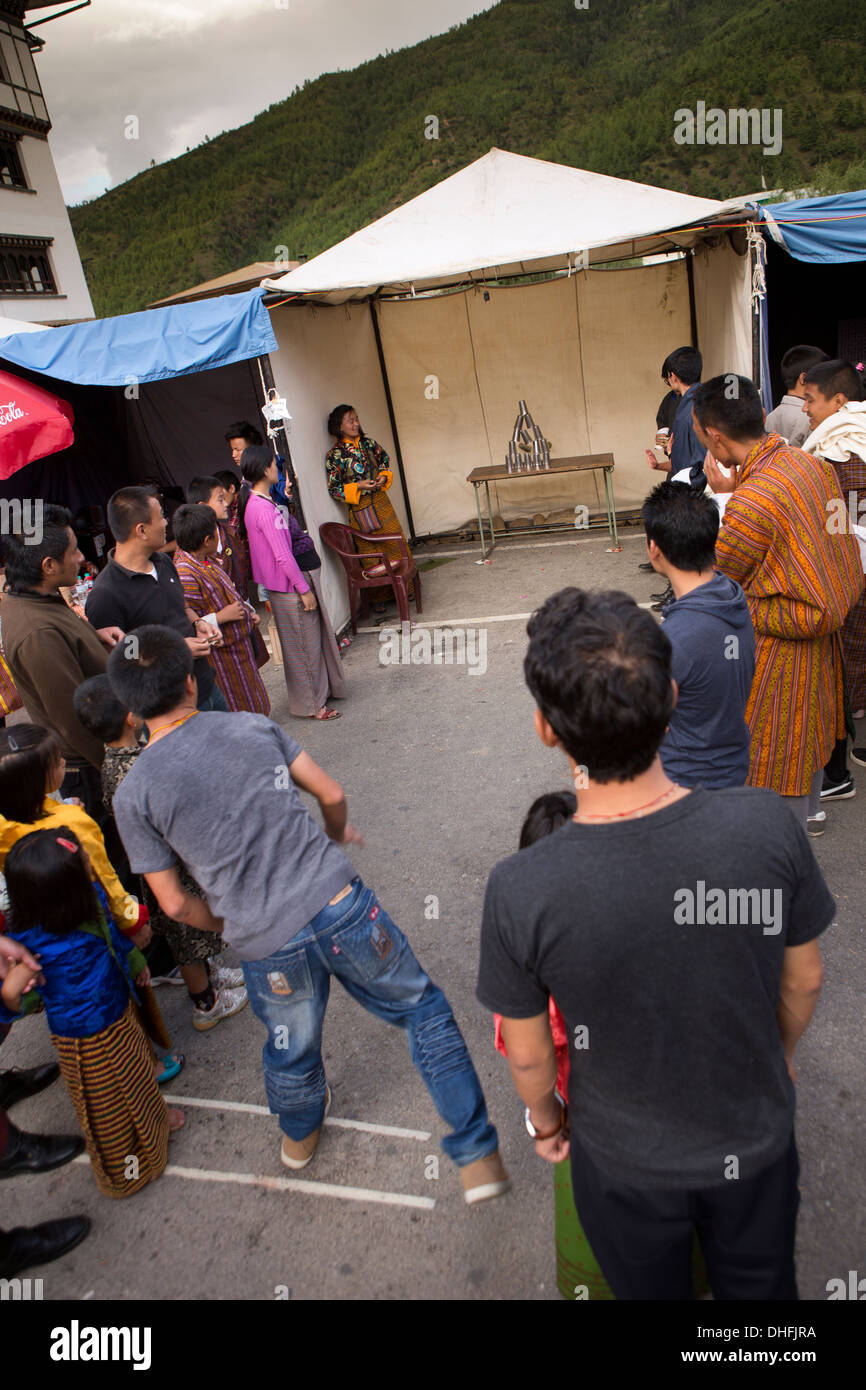 Le Bhoutan, Thimphu, Norzim Lam, Tsechu market stall homme jouant de renverser des boîtes en fer jeu Banque D'Images