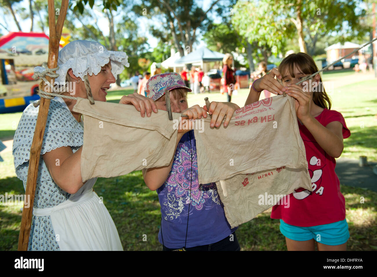 Les enfants de suspendre des vêtements lavés à sécher à l'aide des chevilles en bois à l'ancienne, à Pioneer juste, Guildford, l'ouest de l'Australie Banque D'Images