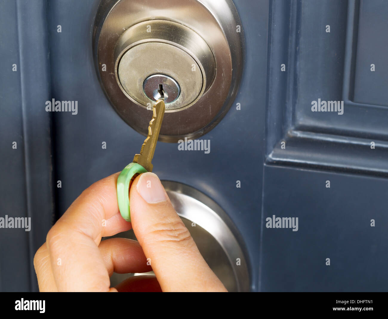Main de femme Photo de mettre la clé dans la maison de chambre de porte avant Banque D'Images