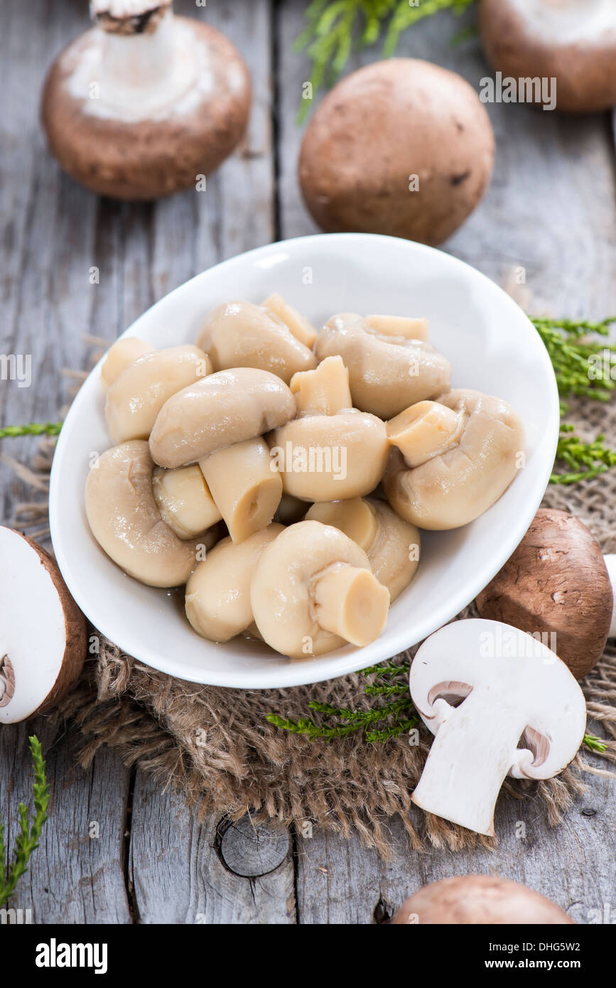 Partie de champignons en conserve sur fond de bois Banque D'Images