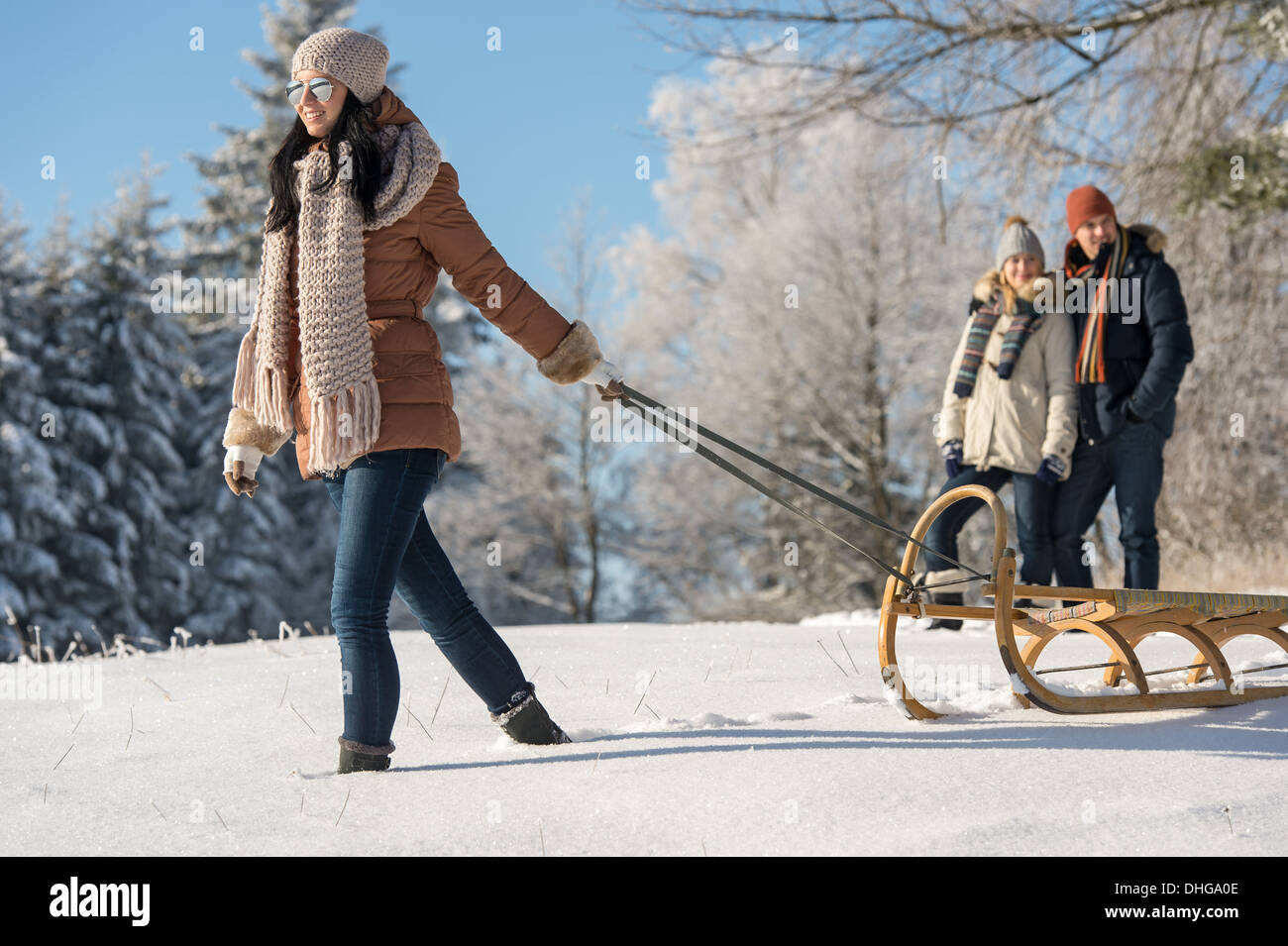 Jeune femme tirant traîneau d'hiver en train de marcher dans la neige campagne Banque D'Images