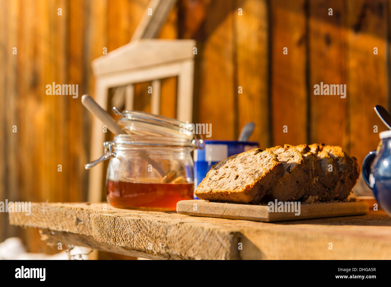 Petit-déjeuner d'hiver à l'extérieur de maison en bois, pain, thé et miel Banque D'Images