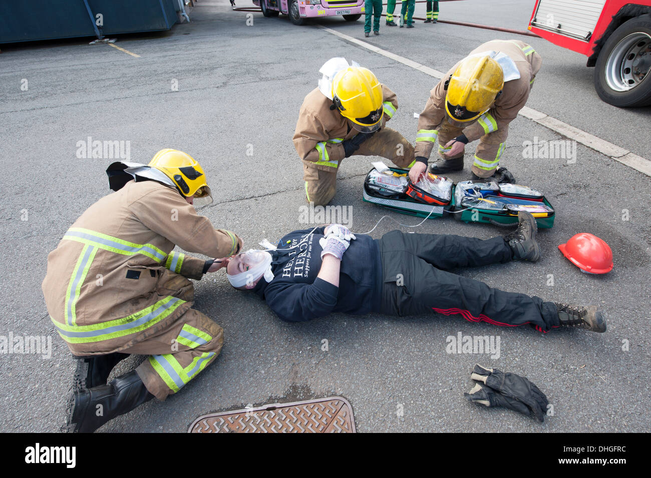 Les pompiers de l'administration des premiers soins à la simulation des blessures Banque D'Images