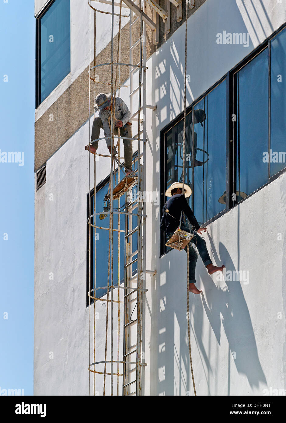 Nettoyage de vitres à travailler sur un bâtiment élevé. S. E. Asie Thaïlande Banque D'Images